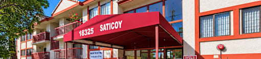 A red and white building with the sign "SATICOY" on it.