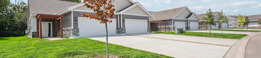 a house with a driveway and a tree in front of it