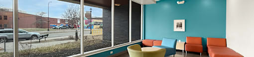 The front lobby of West Broadway Crecent with a blue wall and a yellow chair.