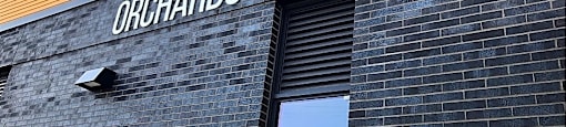 A building with a sign that says "Orchards of 82ND".