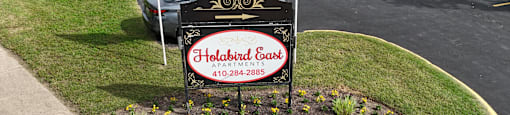 A sign for Holiday Inn Express is in the foreground with a parking lot in the background.