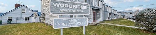 A sign for Woodridge Apartments stands in front of the building.