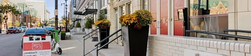 a bicycle parked in front of a building with flowers on the sidewalk