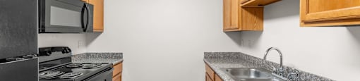 A kitchen with wooden cabinets and black appliances.