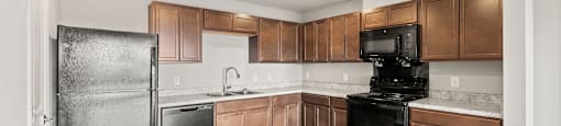 A kitchen with wooden cabinets and black appliances.
