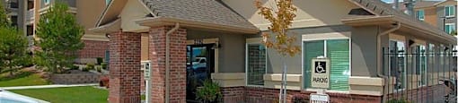 A small building with a brick pillar in front of it.
