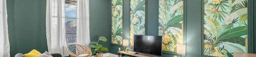 a living room with green walls and a television