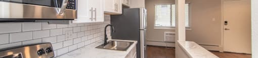 Renovated kitchen with granite countertops and white cabinetry