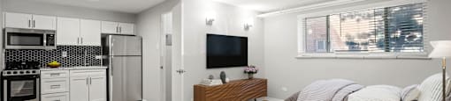 A modern living room with a kitchen area in the background at 1355 Pearl in Denver, CO