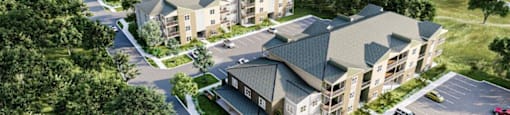 An aerial view of a residential area with houses and parked cars.