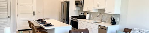 a kitchen and living room with a table and chairs