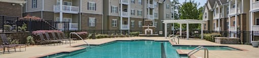 A large swimming pool in front of apartment buildings.