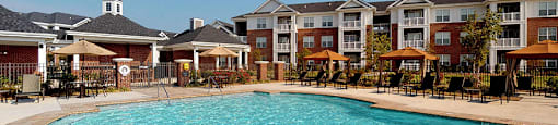 A large swimming pool in front of apartment buildings.