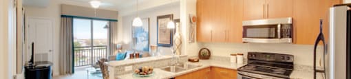 Kitchen with stainless steel appliances; open to living room; sliding door to exterior