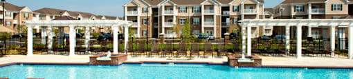 Resort-style pool with pergolas, fountains and chairs