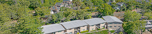 A large building surrounded by trees and a parking lot.