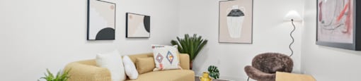 A living room with a yellow sofa, a white coffee table, and a grey rug.