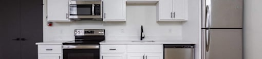 A kitchen with white cabinets and stainless steel appliances.
