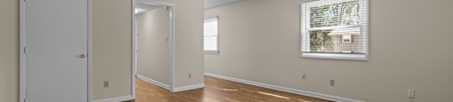the living room and dining room of an empty house with wood flooring at Raleigh Rentals, North Carolina, 27604