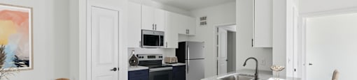 A kitchen with a white table and chairs and a blue island.