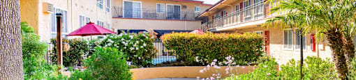 courtyard with lush landscaping and view of exterior of buildings