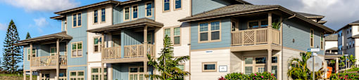 A row of houses with balconies and flower pots in front.
