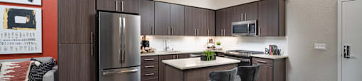 a kitchen with stainless steel appliances and a island with three stools