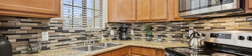 A kitchen with wooden cabinets and a granite countertop.