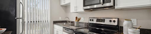 a kitchen with white cabinets and stainless steel appliances