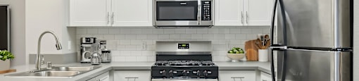 A modern kitchen with stainless steel appliances and white cabinets.