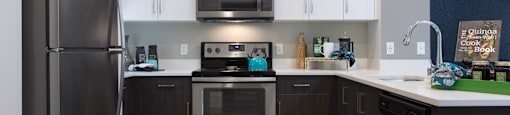 a kitchen with white cabinets and stainless steel appliances