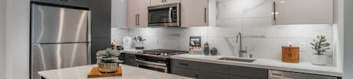 a kitchen with stainless steel appliances and a marble counter top