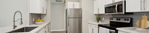 a kitchen with white cabinets and stainless steel appliances