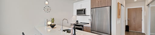 a kitchen with a large island and a stainless steel refrigerator