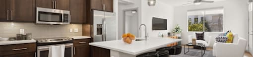 a kitchen and living room with a large white counter top