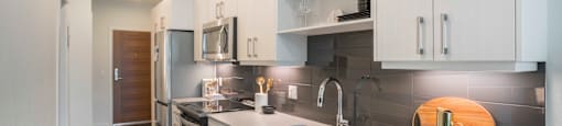 a kitchen with white cabinets and stainless steel appliances