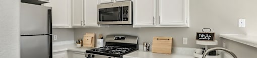 a kitchen with stainless steel appliances and white cabinets