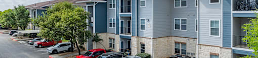 A parking lot with cars and apartment buildings in the background.