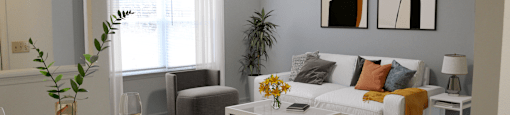 a living room with a white couch and yellow and gray accents