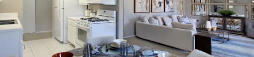 Spacious apartments with lots of natural light, spacious living room, spacious dining room, huge apartment, spacious floor plan, bright white kitchen, white kitchen cabinets, and gray wall color at Inwood Apartments in La Vista, Nebraska