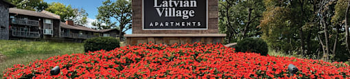 the sign apartments in front of red flowers