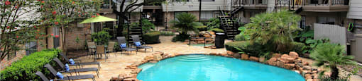 Gated apartment community with pool, spa, poolside lounge chairs, lush landscaping, beautiful landscaping, and neighborhood setting in Houston, Texas