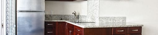 Waikiki Walina Apartments kitchen area with appliances, cabinets, and counters