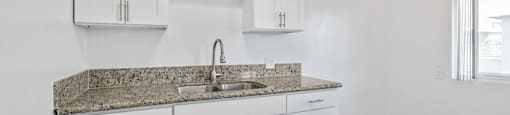 a kitchen with white cabinets and a granite counter top
