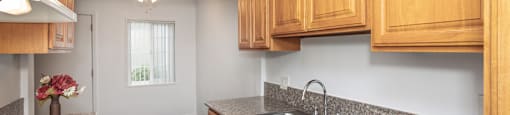 A kitchen with wooden cabinets and a stove top.