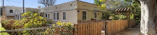 a house with a fence and a sidewalk in front of it
