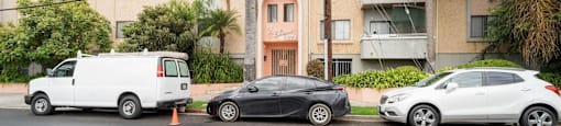 three cars parked in front of an apartment building