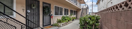 A residential area with a building that has a balcony and a small garden.