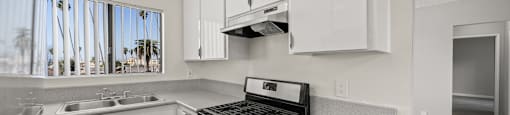 A kitchen with a stove top oven and a sink.