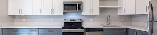 A kitchen with white cabinets and a wooden floor.